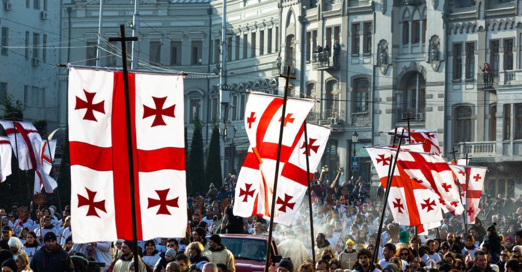 crowd-of-people-waving-flags-of-georgia-during-celebration-of-religious-holiday-on-christmas-day-in