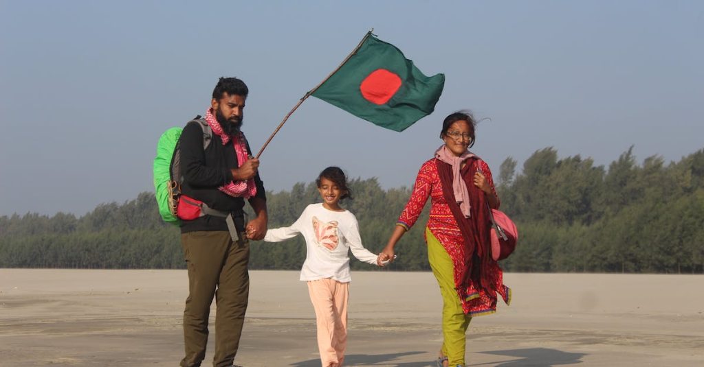 family-with-a-bangladesh-flag-walking-by-the-beach