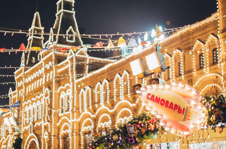 low-angle-of-exterior-of-old-building-decorated-with-small-round-white-lamps-during-christmas-holida