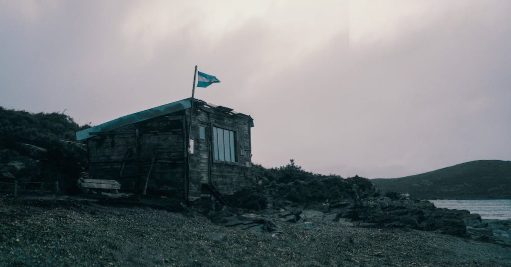 wooden-house-with-a-flag-of-argentina-near-the-sea